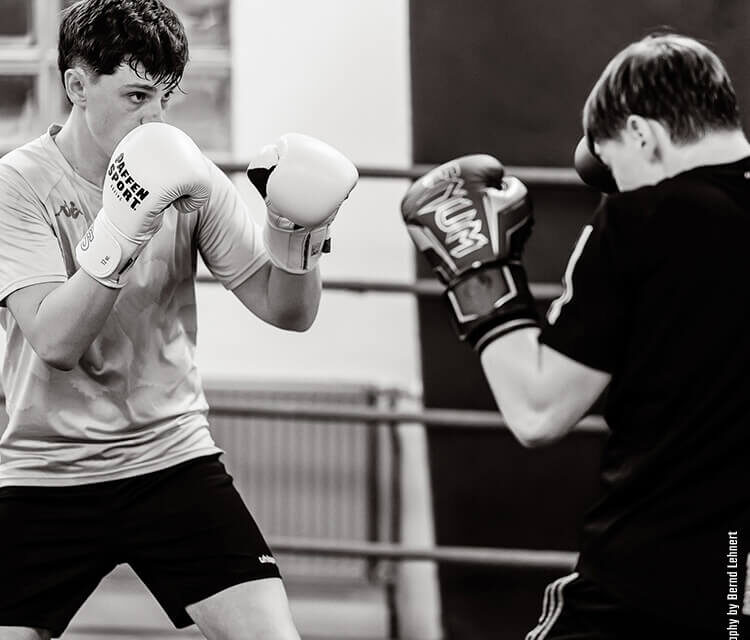 Boxclub Köln für Kinder: Zwei Jugendliche machen im Boxring Sparring während des Boxunterrichts im Combat Club – einem Boxclub in Koeln Zentrum