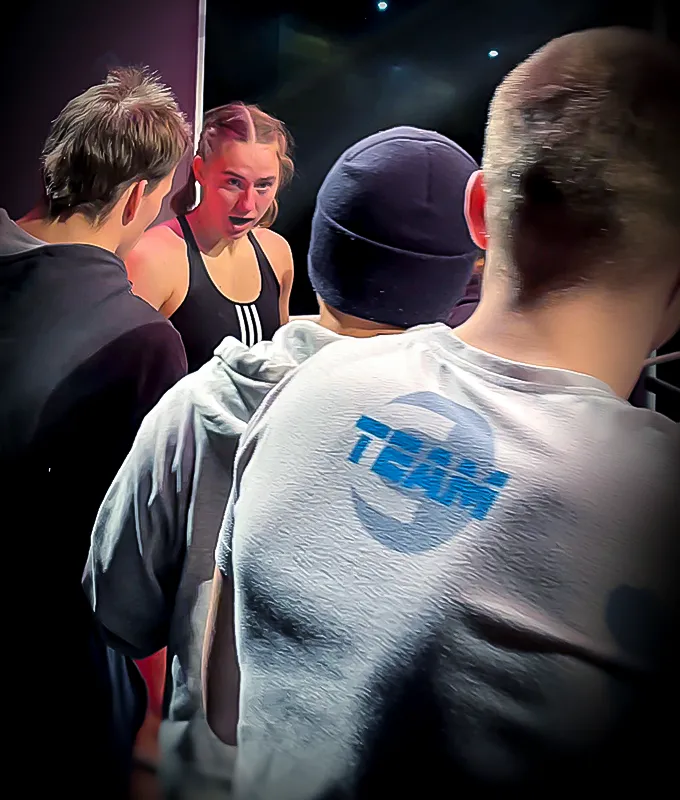 Das Combat Club Team unterstützt die junge Boxerin aus ihrem Team bei ihrem Boxkampf während der Pause.